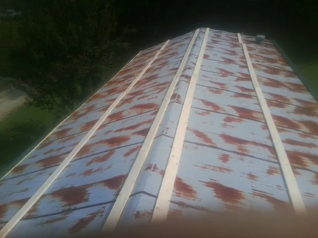 Rusted metal roof panels with new wood purlins before replacement — Storm Damage Roof Repair in Donalds by Roofing Brothers