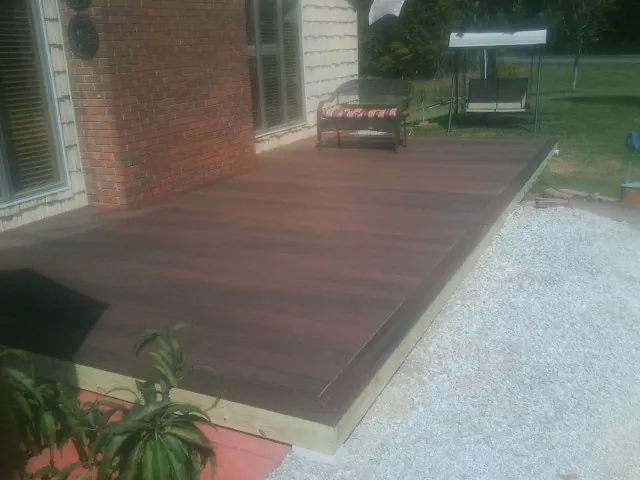 Freshly stained wood deck built against a brick home in Donalds