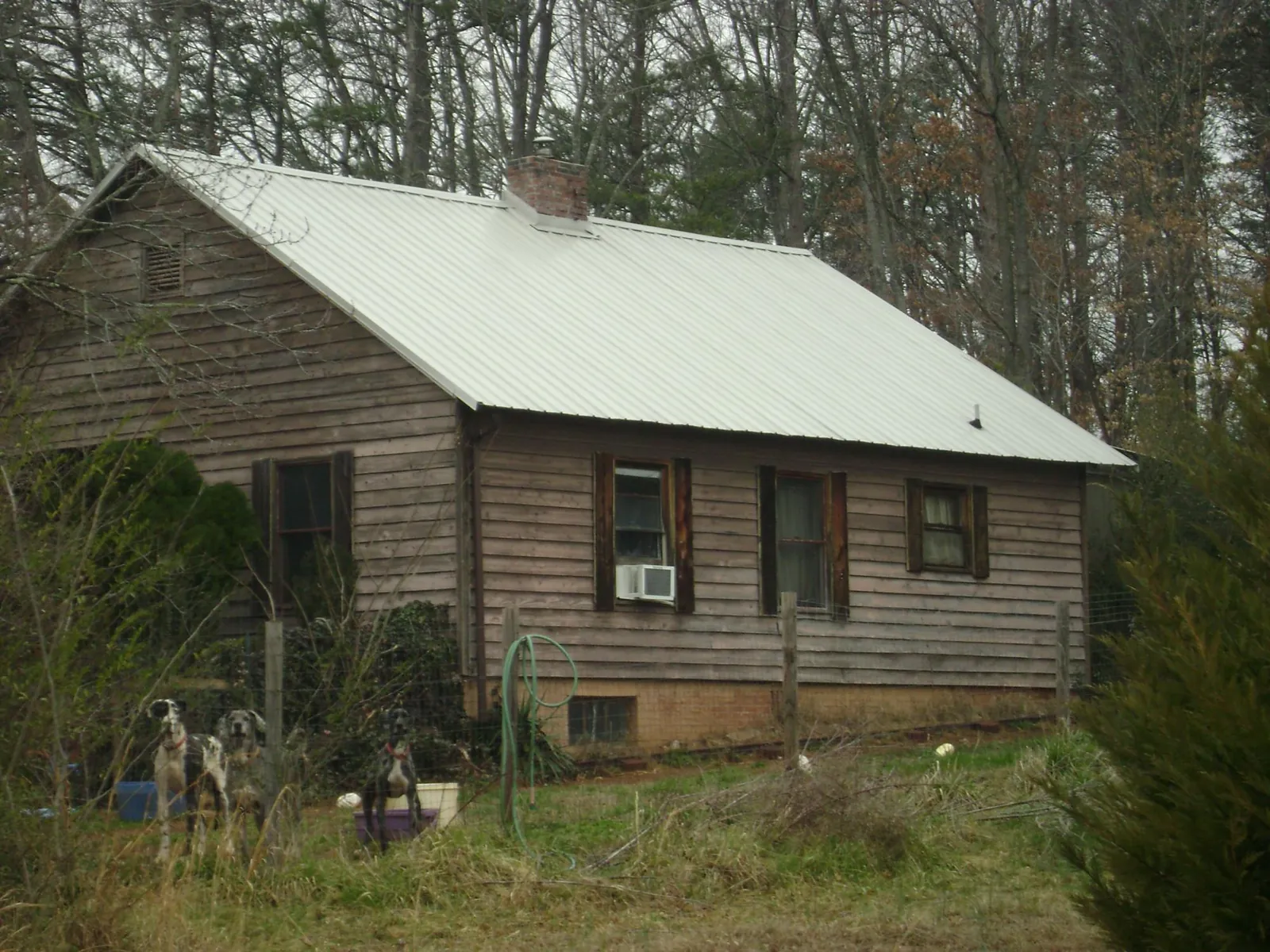 White metal roof on an old wood sided farmhouse, from a Metal Roof Installation job in Donalds